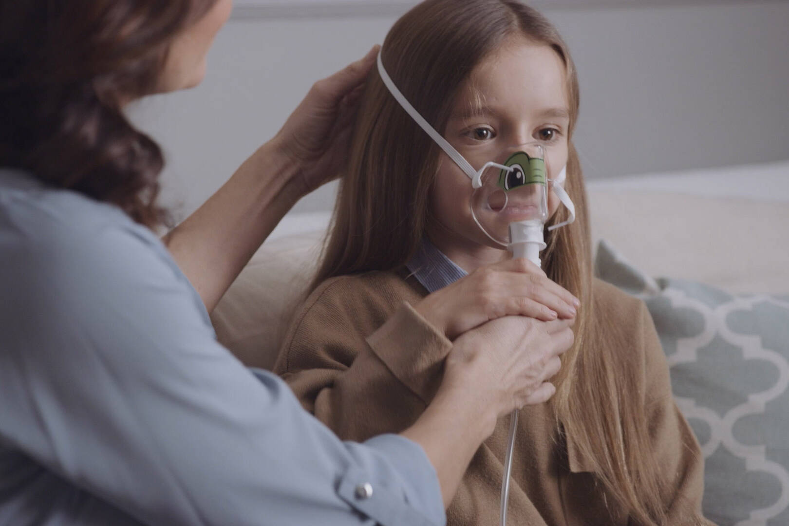 Close-up of young girl wearing Philips nebuliser mask with parental guidance, featured in respiratory care video filmed by Sugarhill