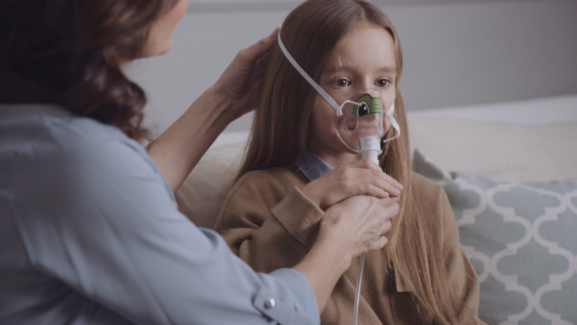 Close-up of young girl wearing Philips nebuliser mask with parental guidance, featured in respiratory care video filmed by Sugarhill